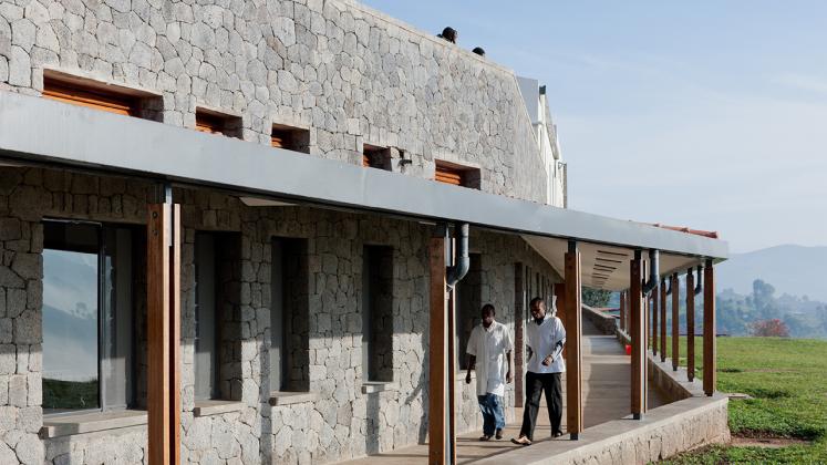 Photo of Butaro District Hospital, Photo by Iwan Baan, Exterior Hallway with Doctor and Patient Passing By