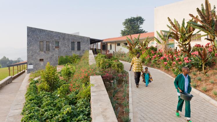 Photo of Butaro District Hospital, Photo by Iwan Baan, Visitors and Patients walk along outdoor corridors