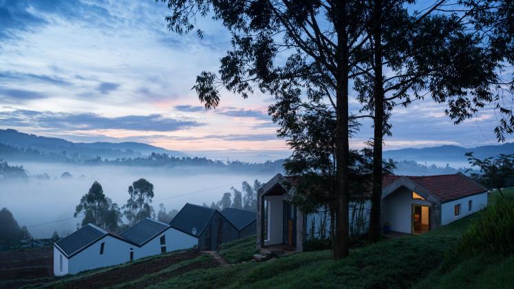 Photo of Butaro Doctors' Sharehousing, Photo by Iwan Baan, Exterior Evening View of the Sharehousing Units, facing Downhill