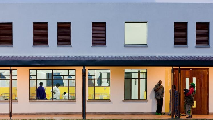 Photo of Butaro District Hospital, Photo by Iwan Baan, Nightitme View of Exterior Hallway with View into Hospital Rooms 