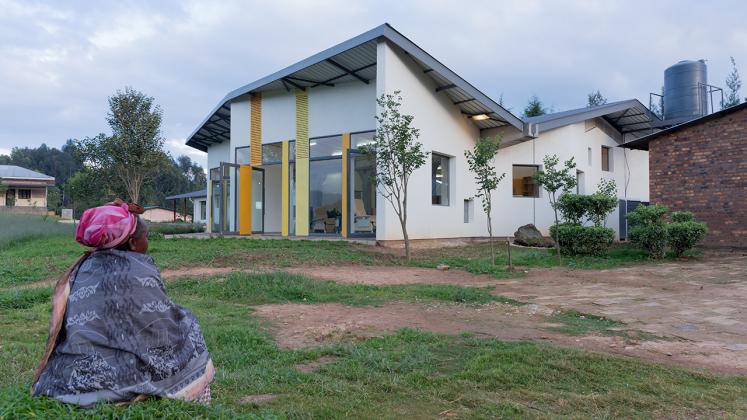 Photo of Butaro Ambulatory Cancer Center, Photo by Iwan Baan, Daytime Exterior of the Building with Woman