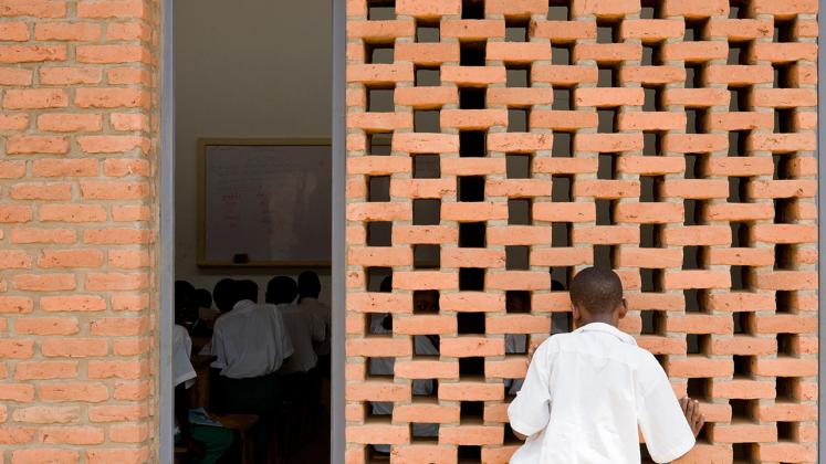 Photo of the Umubkano Primary School, Photo by Iwan Baan, View of Custom Brick Wall with Gaps for Ventilation into Primary School Classroom